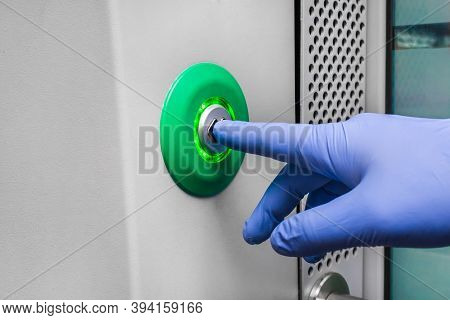 A Man's Hand In A Protective Medical Glove Presses The Door Control Button In A Modern Electric Trai