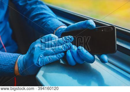 Hands Of A Man In Protective Medical Gloves Holding A Mobile Phone