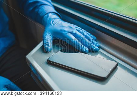 The Hand Of A Man In Protective Medical Gloves Lies Next To A Mobile Phone
