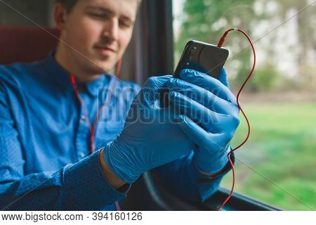 A Guy In Protective Medical Gloves Sits On The Phone And Listens To Music, Close-up