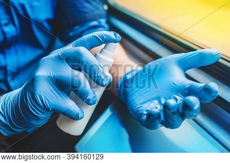 Businessman Hands In Protective Medical Gloves Hold And Spray Antiseptic, Soft Focus