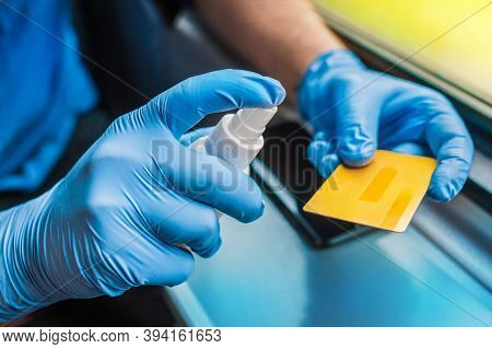 Man's Hand In Protective Medical Gloves Holds An Antiseptic And A Bank Card, Close Up