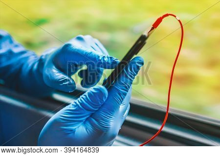A Man In Protective Medical Gloves Sits In The Phone And Listens To Music On Headphones, Soft Focus