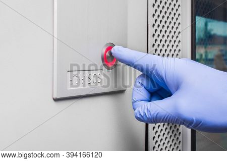A Man's Hand In A Protective Medical Glove Presses The Sos Button In A Modern Electric Train, Close-