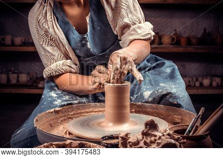 Hands Of The Master Potter And Vase Of Clay On The Potters Wheel Close-up. Master Crock. Twisted Pot