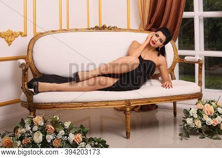 Sexy Beautiful Woman In Black Dress Lying On Couch