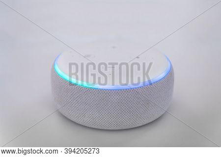 Amazon echo dot , Alexa voice controlled speaker with activated voice recognition, on brick and white background