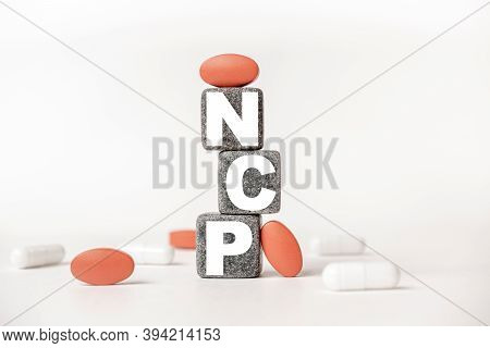 A Group Of White And Red Pills And Cubes With The Word Ncp Nursing Care Plan On Them, White Backgrou
