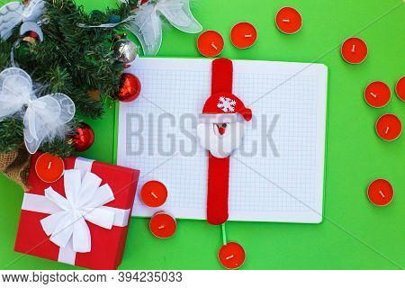 Christmas Gift, Presrnt Box, Many Red Candles, Notepad For Writing And Fir Tree Branches With Toys.
