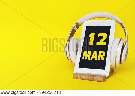 March 12nd. Day 12 Of Month, Calendar Date. Stylish Headphones And Modern Tablet On Yellow Backgroun