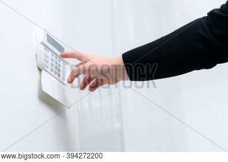 Hand Entering Alarm System Password Of An Apartment, Home Or Business Office. Surveillance And Prote