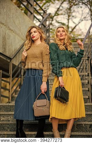 Sweater Skirt Trend. Matching Outfits. Women Sisters Outdoors Stairs Background. Matching Colors. Pe