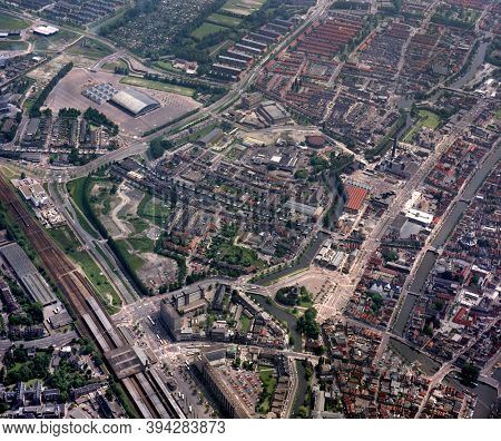 Leiden, Holland, June 17- 1985: Historical aerial photo of the Station neighbourhood with windmill the Valk, Groenoordhallen and Central Station