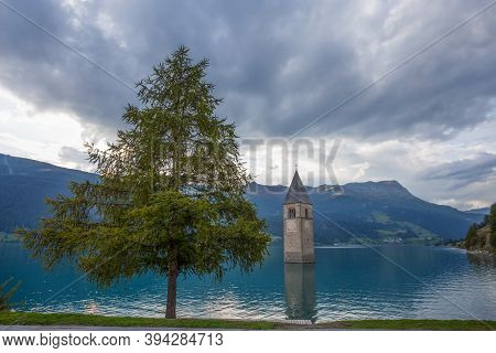 The Bell Tower Of The Sunken Church In Curon, Resia Lake, Bolzano Province, South Tyrol, Italy.
