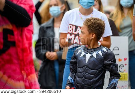 Richmond, North Yorkshire, Uk - June 14, 2020: Young Superhero Plays With Action Figures While Prote