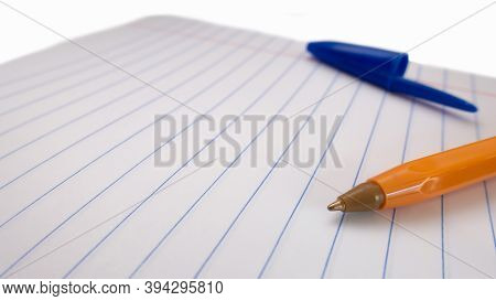 Close-up Yellow Pen On A Ruler Notebook. Against The Background Of A Blue Cap.