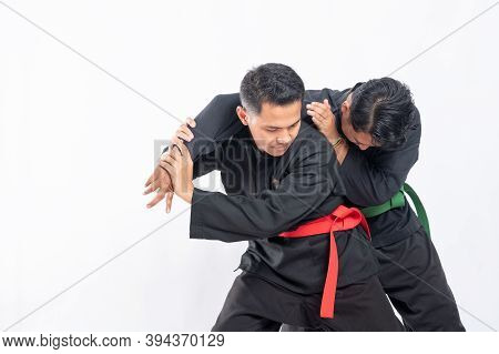 Male Fighters In Black Pencak Silat Uniforms Fight By Holding And Locking Their Opponents Hands With