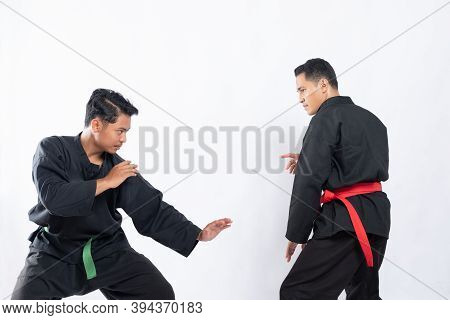Two Fighters In Pencak Silat Hitam Uniform Fight In Low Stance And Side Stance Movements