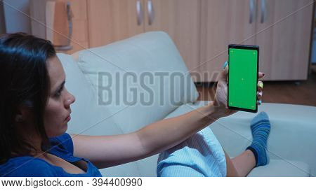 Lady Reading On Smartphone Monitor With Green Screen Lying On Sofa In Living Room. Woman Holding A M