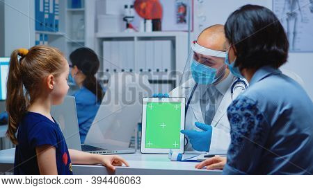 Doctor Using Green Screen Tablet In Medical Office During Covid-19. Healthcare Specialist With Chrom
