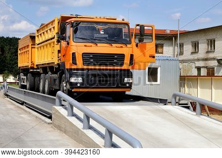 Orange Truck With Grain Is Weighed On The Scales In The Grain Storage Area. Truck Scales