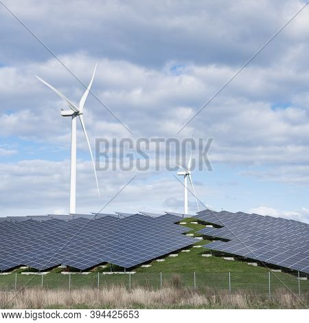 Wind Turbines And Solar Panels Form Alternative Enery Plant In The Netherlands Under Blue Sky With C