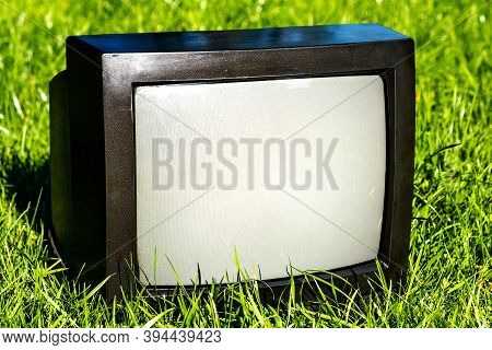 Old Analog Television Set On The Grass Outdoor