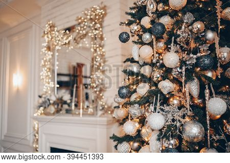 A Fragment Of A Christmas Decorated Tree In Warm Golden Colors On A Brurred White Classic Room Inter