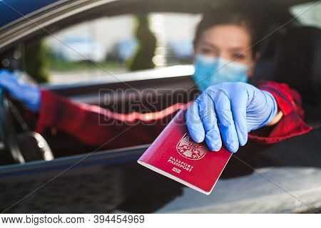 Young Caucasian Female Driver Wearing Medical Face Mask And Protective Gloves Handing Over Red Immun