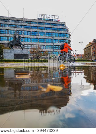 Wroclaw October 10 2019 Cyclist In Front Of Renoma Mall Reflected In Puddle