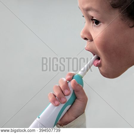 Little Boy Brushing His Teeth With An Electric Tooth Brush Stock Image With Grey Background Stock Ph