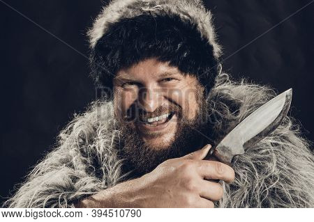 Bearded Hunter Dressed In A Fur Mantle And Fur Hat With Knife
