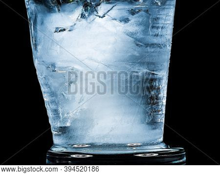 Ice Melts And Rotates On A Black Background. Extreme Close Up. Crystal Ice Cube With Frozen Water Th