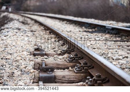 Wooden Sleeper On An Old Railroad Track With Railway White Ballast In A Curve, On A Line Used For Ca