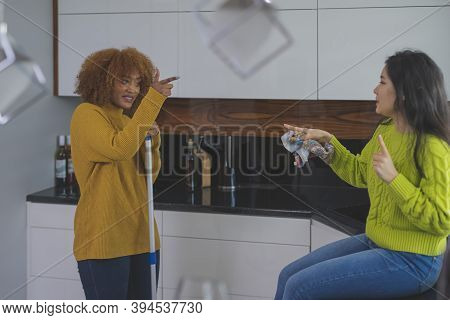 Best Friends Roommates Having Fun While Cleaning Kitchen. Singing And Dancing. Healthy Relationship 