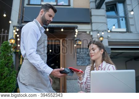 Waiter Holding Payment Machine, Brown-haired Female Paying Bill With Smartphone