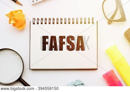 The Word Fafsa In A Notebook On White Table With Office Tools. Business Concept.