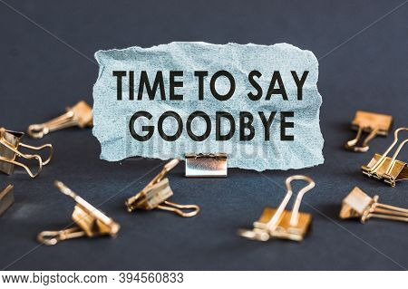 A Scrap Of Blue Paper With Clips On A Gray Background With The Text - Time To Say Goodbye.