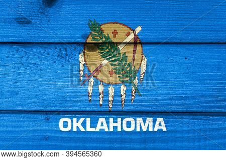 Oklahoma Flag Painted On Old Wood Plank Background. Brushed Natural Light Knotted Wooden Board Textu