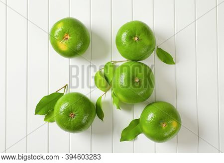 Five whole sweetie fruits (green grapefruits, pomelits) and leaves