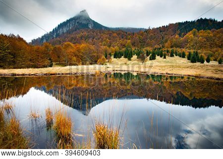 Scenic autumn view of small lake at Roosterâs Ridge, Gutaiului Mountains, Romania.