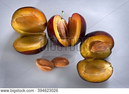 Segments Of Plum And Stone On A White Background