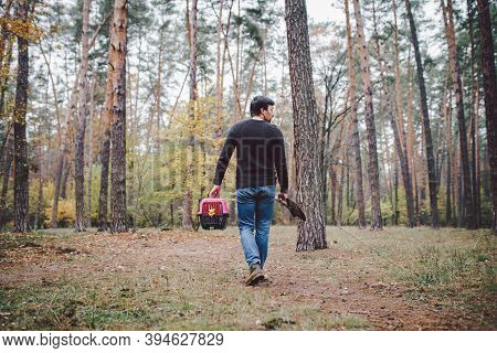 Man Still In Forest Carrying Transport Box Inside With Dead Pet And Shovel For Burying Animal In Woo