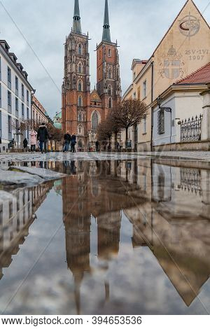 Wroclaw December 25 2019 Old Cathedral In Wroclaw Ostrow Tumski Reflected In Small Puddle