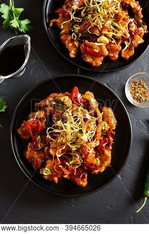 Spicy Garlic Fried Chicken (kkanpunggi). Asian Chicken In Sweet And Sour Sauce On Plate Over Black S