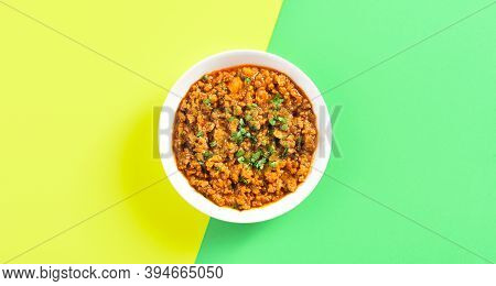 Keema Curry In Bowl Over Yellow Green Background With Copy Space. Indian And Pakistani Style Dish. T