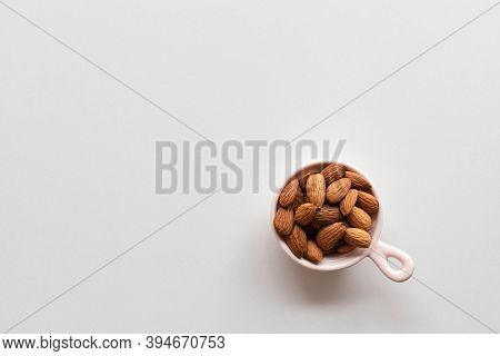 Fresh Almonds Nuts In Pink Plate On A White Background. Flat Lay, Top View, Copy Space.