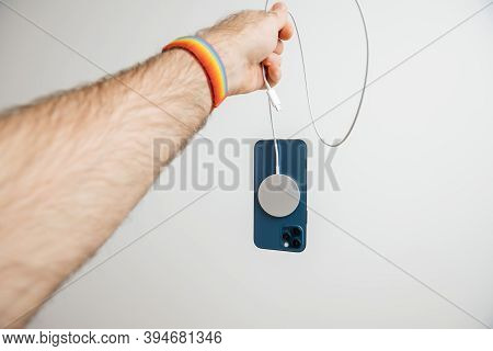 Paris, France - Nov 11, 2020: Man Hand Holding By Lighting Cable The Magsafe Wireless Magnetic Charg