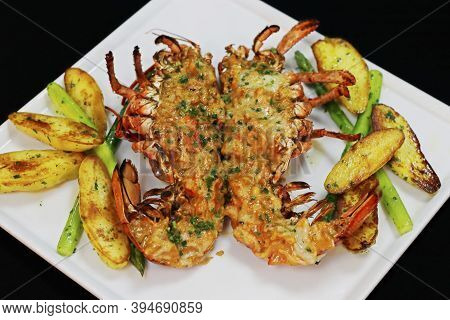 Lobster Thermidor Served With Glazed Potato And Asparagus In A Platter, Black Background