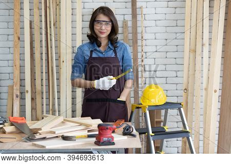 Beautiful Asian Adult Woman Wearing Jeans Clothes Working As A Carpenter In Room At Home. Concept Fo